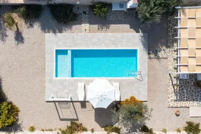 an overhead view of a swimming pool with an umbrella and an umbrella at Kalathos Dream Villas in Kalathos