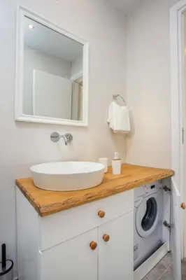 a bathroom with a sink and a washing machine at Kalathos Dream Villas in Kalathos