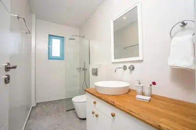 a white bathroom with a sink and a toilet at Kalathos Dream Villas in Kalathos