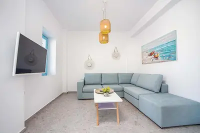 a living room with a blue couch and a table at Kalathos Dream Villas in Kalathos