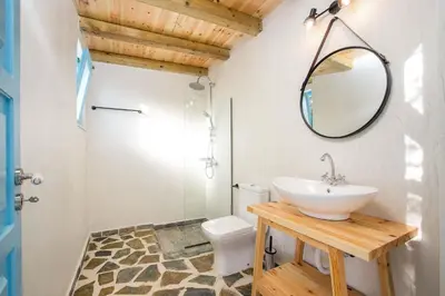 a bathroom with a sink and a mirror and a toilet at Kalathos Dream Villas in Kalathos