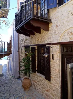 a building with a balcony and a potted plant at Muse Mese in Halki