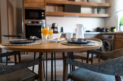 a kitchen with a wooden table with two glasses of orange juice at Anastasia Grand Villa in Kattavía