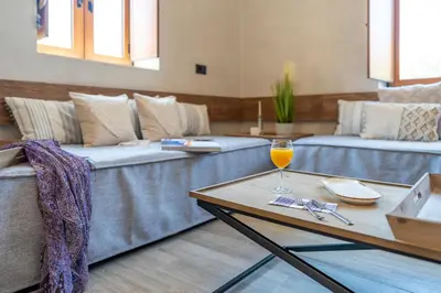 a living room with couches and a glass of wine on a table at Anastasia Grand Villa in Kattavía