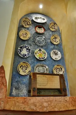 a wall with plates on it with a clock at Casa DimiGre house in Kattavia - Prasonisi Rhodes in Kattavía