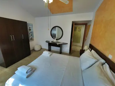 a bedroom with a large bed and a mirror at Casa DimiGre house in Kattavia - Prasonisi Rhodes in Kattavía