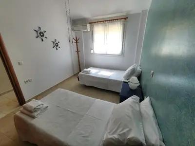 a small bedroom with two beds and a window at Casa DimiGre house in Kattavia - Prasonisi Rhodes in Kattavía