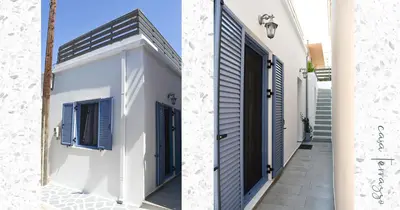 a white house with blue shutters and a hallway at Casa terrazzo in Paradeísion