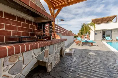 a brick house with a swimming pool and a patio at Dorieus Villa in Lachania