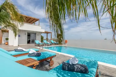 a pool with chaise lounge chairs and a swimming pool at Dorieus Villa in Lachania