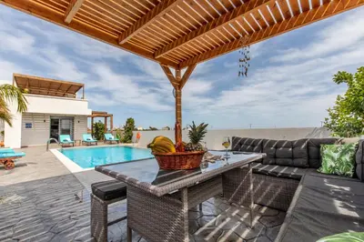 a patio with a table and a couch and a pool at Dorieus Villa in Lachania