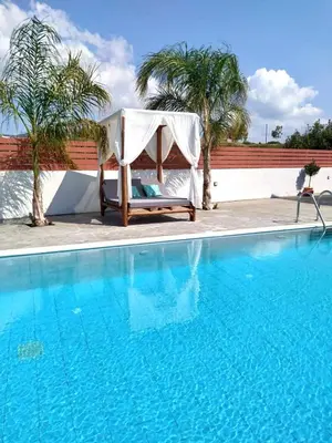 a chair sitting next to a swimming pool at Dorieus Villa in Lachania