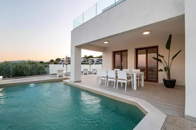 a house with a swimming pool and a table and chairs at Villa Oriens in Gennadi