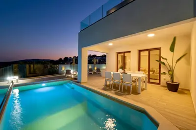 a house with a swimming pool and a dining area at Villa Oriens in Gennadi