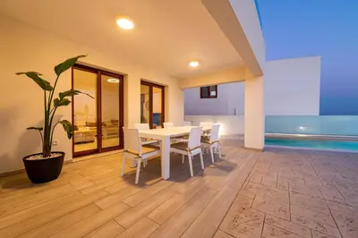 a dining room with a table and chairs and a potted plant at Villa Eventide in Gennadi