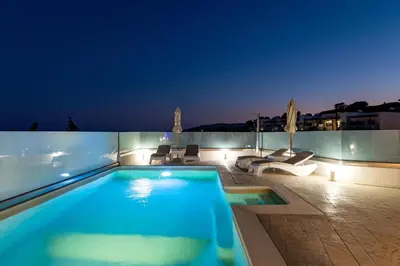 a swimming pool on the roof of a building at night at Villa Eventide in Gennadi