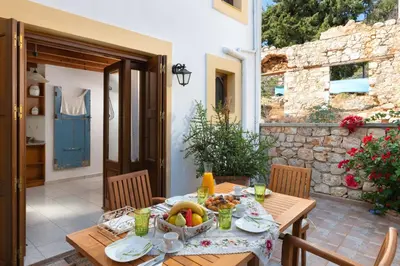 a wooden table with a bowl of fruit on it at Little Karafillias Chalki House in Halki
