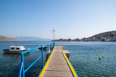a boat is docked at a dock in the water at Little Karafillias Chalki House in Halki