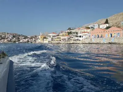 a boat in a body of water with buildings at Little Karafillias Chalki House in Halki