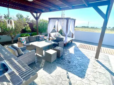 a patio with a couch and a table and chairs at Kallipateira Villa in Lachania