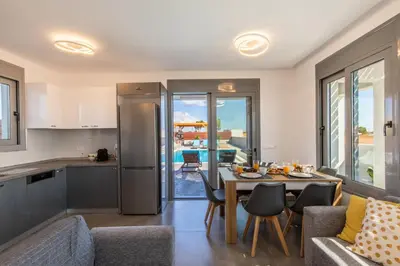 a kitchen and living room with a table and chairs at Kallipateira Villa in Lachania