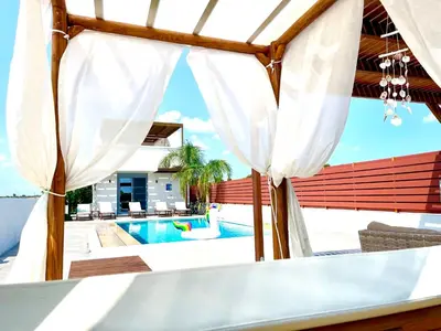 a view of a pool from a patio with white curtains at Kallipateira Villa in Lachania