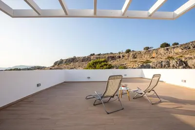 two chairs and a table in a room with a mountain at Villa Sophia in Pefki Rhodes