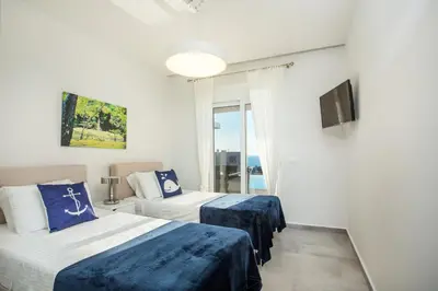 a hotel room with two beds and a television at Villa Sophia in Pefki Rhodes