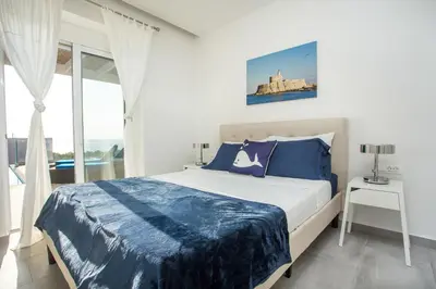 a bedroom with a large bed with blue pillows at Villa Sophia in Pefki Rhodes