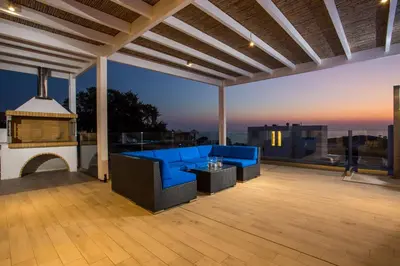 a patio with a blue couch and a table at Villa Sophia in Pefki Rhodes
