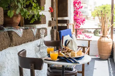 a table with a plate of food and orange juice at Koukos Rodos Boutique Hotel & Spa - Adults Only in Rhodes Town
