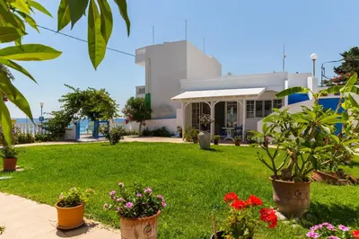 a garden with flowers in front of a building at Antonios Apartments Stegna in Archangelos