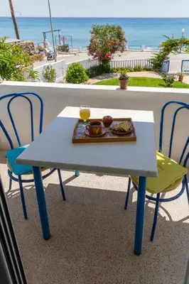 a table and chairs with a plate of food on it at Antonios Apartments Stegna in Archangelos
