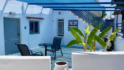 a patio with chairs and a table and stairs at Iris Studios in Archangelos