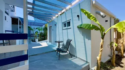 a patio with a table and a blue building at Iris Studios in Archangelos