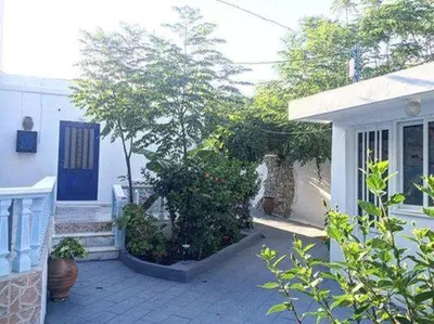 a porch of a house with a blue door at Iris Studios in Archangelos