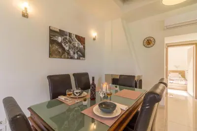 a dining room with a glass table and leather chairs at Renes Paradise Seahome - Afandou Beach, Rhodes in Rhodes Town