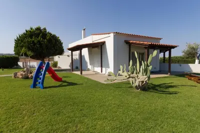 a house with a playground with a slide in the grass at Renes Paradise Seahome - Afandou Beach, Rhodes in Rhodes Town