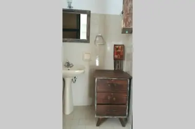 a bathroom with a sink and a wooden dresser at Jimmy΄s Place in Gennadi