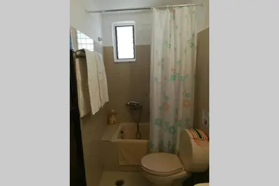a bathroom with a toilet and a shower curtain at Jimmy΄s Place in Gennadi