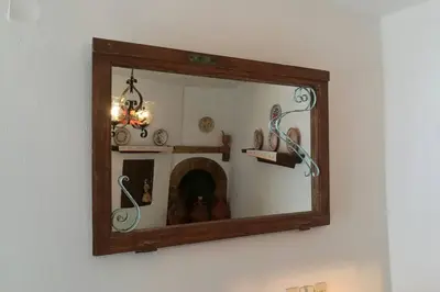 a mirror is hanging on a wall with a shelf at Jimmy΄s Place in Gennadi