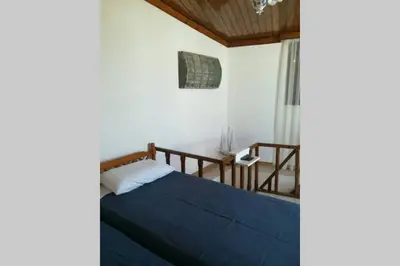 a bedroom with a bed with blue sheets and a window at Jimmy΄s Place in Gennadi