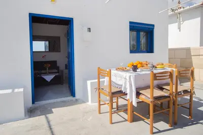 a kitchen with a table with chairs and fruit on it at Endless Blue Stegna in Archangelos