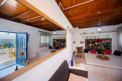 a living room with a couch and a fireplace at Endless Blue Stegna in Archangelos