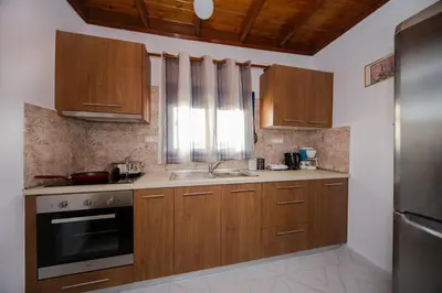 a kitchen with wooden cabinets and a sink at Endless Blue Stegna in Archangelos