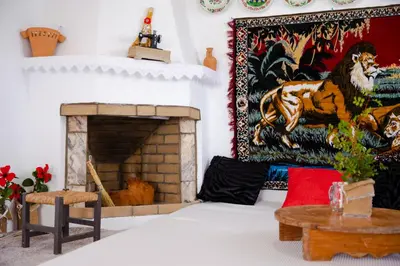 a living room with a fireplace and a tapestry at Endless Blue Stegna in Archangelos