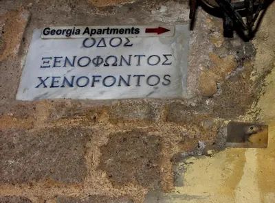 a sign on the side of a brick wall at Rhodes Old town apartment manos in Rhodes Town