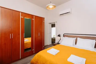 a bedroom with a orange bed and wooden cabinets at Rhodes Old town apartment manos in Rhodes Town