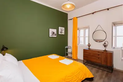 a bedroom with a yellow bed and a green wall at Rhodes Old town apartment manos in Rhodes Town