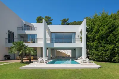 a large white house with a swimming pool at Ixian Hilltop Villa in Triánta